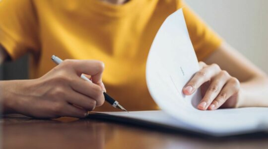 Yellow-shirt-signing-paper